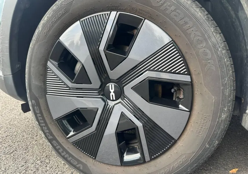 Gros plan sur la jante noire et grise au design géométrique du Dacia Jogger Vert Cèdre métallisé.