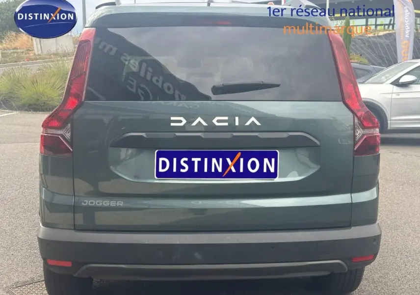 Vue arrière d'un Dacia Jogger 2025 vert cèdre métallisé avec feux verticaux et lunette arrière surteintée.