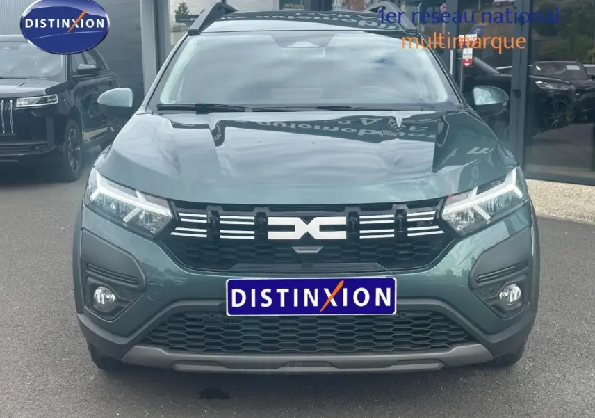 Vue frontale du Dacia Jogger 2025 en Vert Cèdre métallisé avec calandre noire et phares LED allumés.