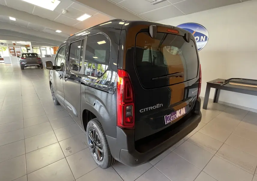 Vue 3/4 arrière droite du Citroën Berlingo noir 2025 avec feux arrière LED et logo visible en showroom.