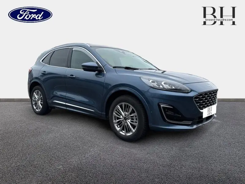 Ford Kuga bleu azur métallisé en 3/4 avant droit, avec toit panoramique et jantes alliage visibles.