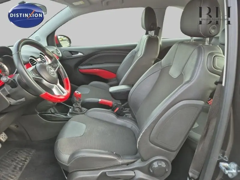 Vue intérieure côté droit de l’Opel Adam Rocks noir avec sellerie cuir mixte noir et touches rouges sur volant et levier de vitesse.