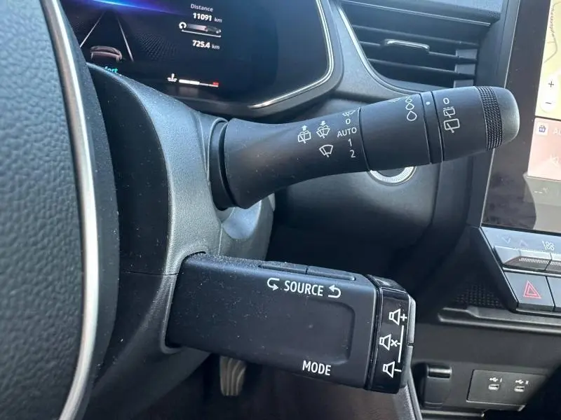 Gros plan sur le commodo gauche du tableau de bord du Renault Captur 2025, avec commandes de phares et essuie-glaces.