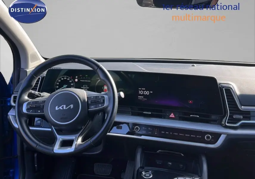 Vue intérieure du tableau de bord et volant noir du Kia Sportage 2022, avec écran tactile large et commandes intégrées.