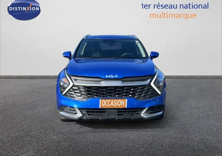 Vue frontale d'un Kia Sportage bleu fusion métal 2022 avec calandre distinctive et feux LED en forme de flèche.