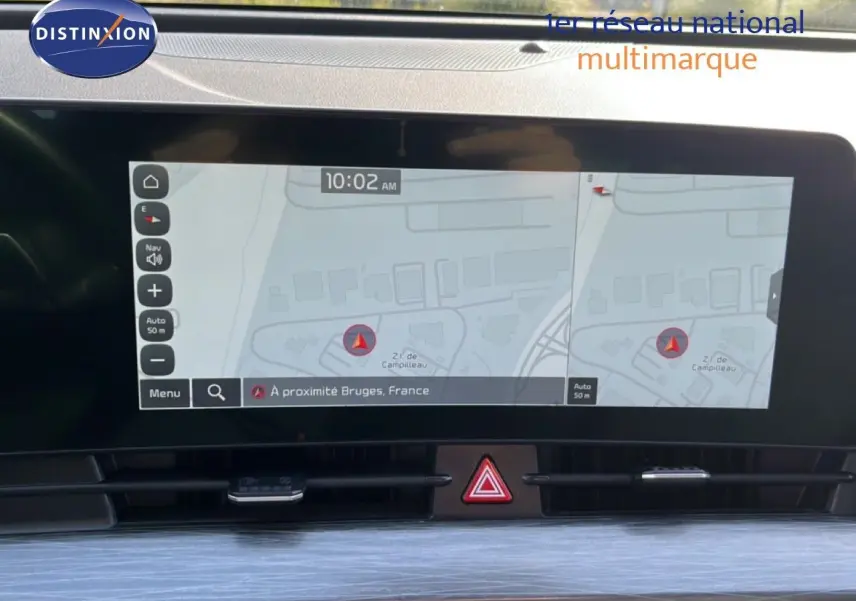 Écran tactile central du Kia Sportage 2022 affichant la navigation avec carte et alertes, intérieur moderne en noir.