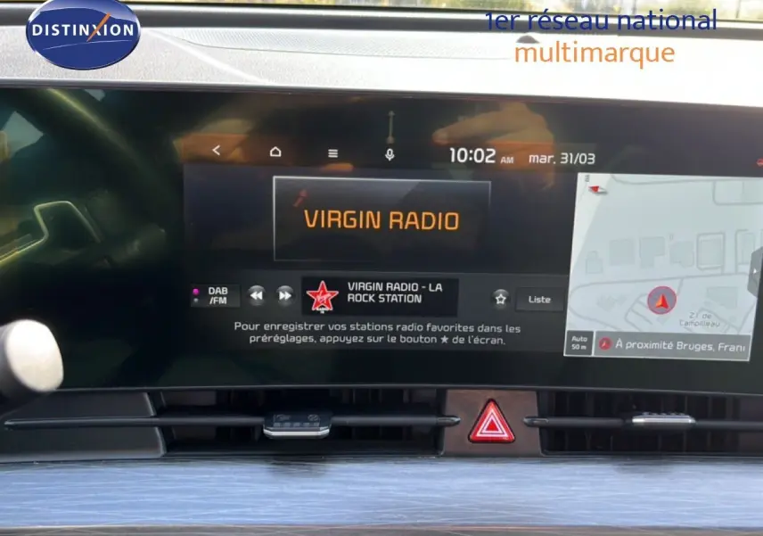 Vue rapprochée de l’écran central tactile du Kia Sportage 2022 bleu fusion, affichant la radio et la navigation.