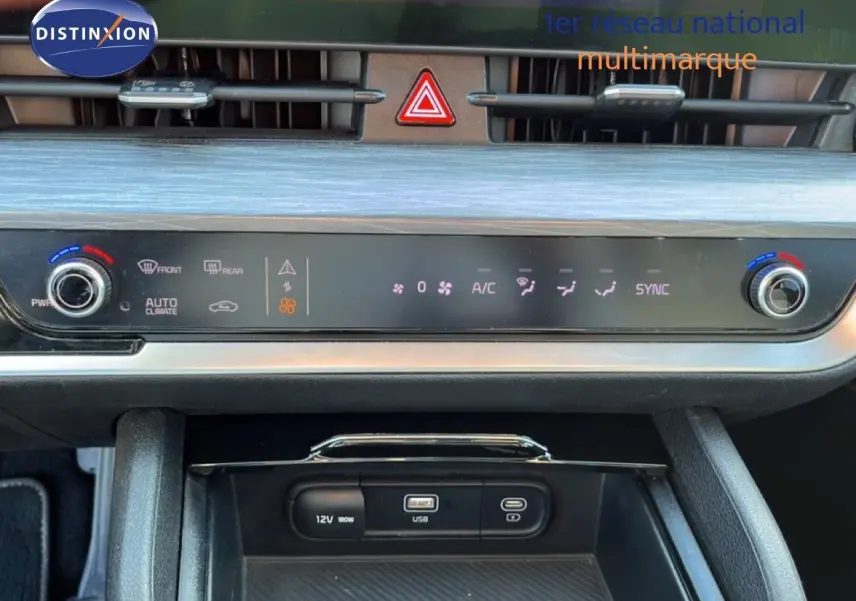 Vue rapprochée du tableau de bord du Kia Sportage bleu fusion métal 2022, mettant en valeur les commandes de climatisation et ports USB.