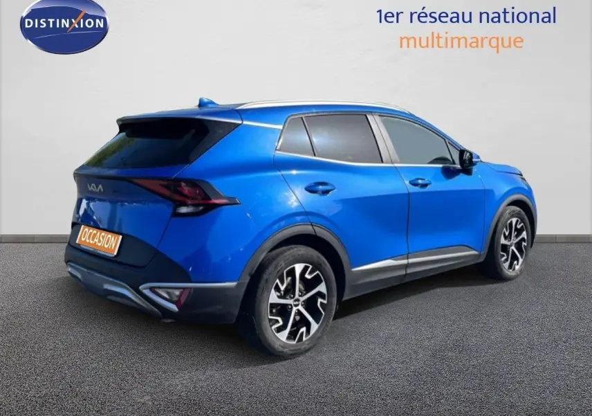 KIA SPORTAGE bleu fusion métal en 3/4 arrière droit, avec jantes alliage noires et détails chromés.