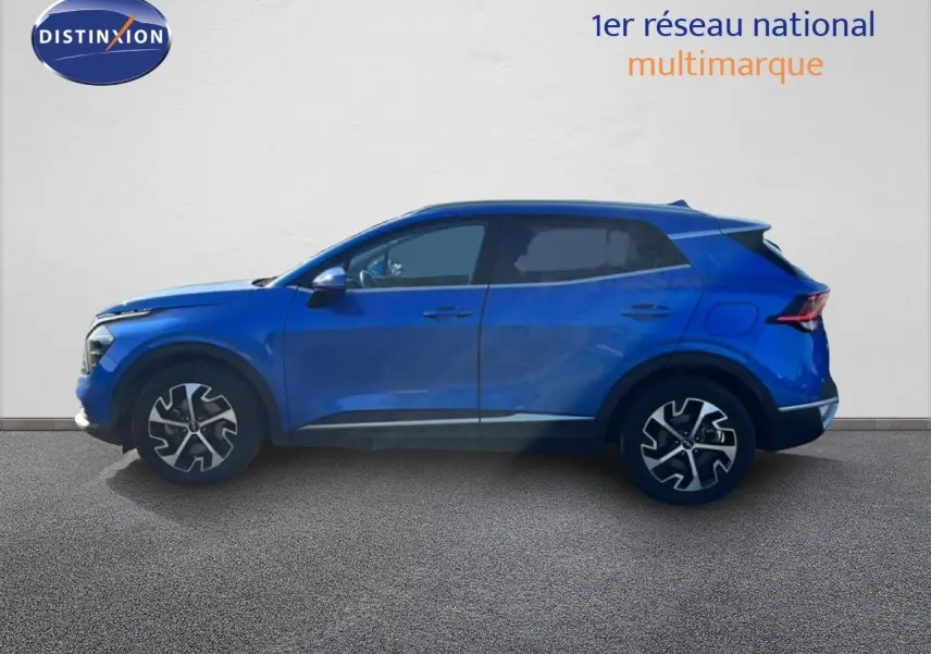 Vue de profil côté gauche d'un Kia Sportage bleu fusion métal 2022 avec jantes alliage bicolores et vitres teintées.