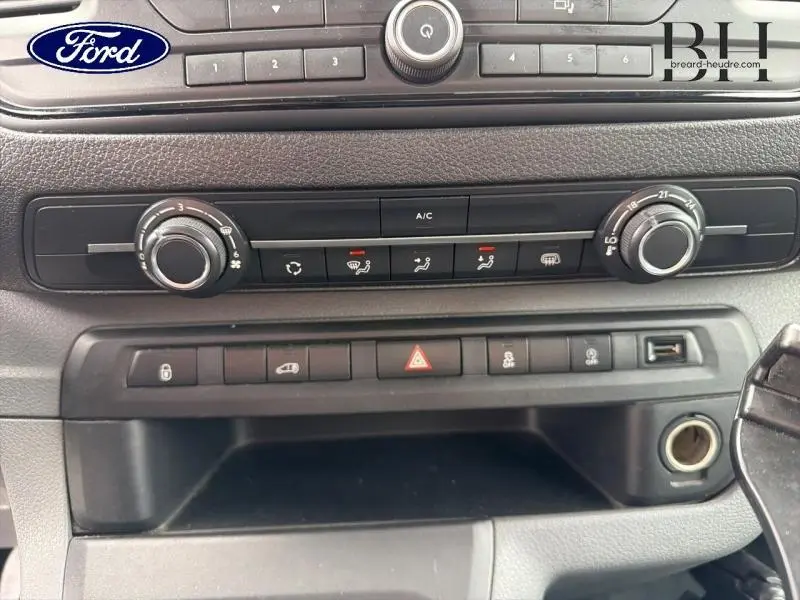Vue rapprochée de la console centrale noire du Citroën Jumpy blanc avec commandes de climatisation et boutons fonctionnels.
