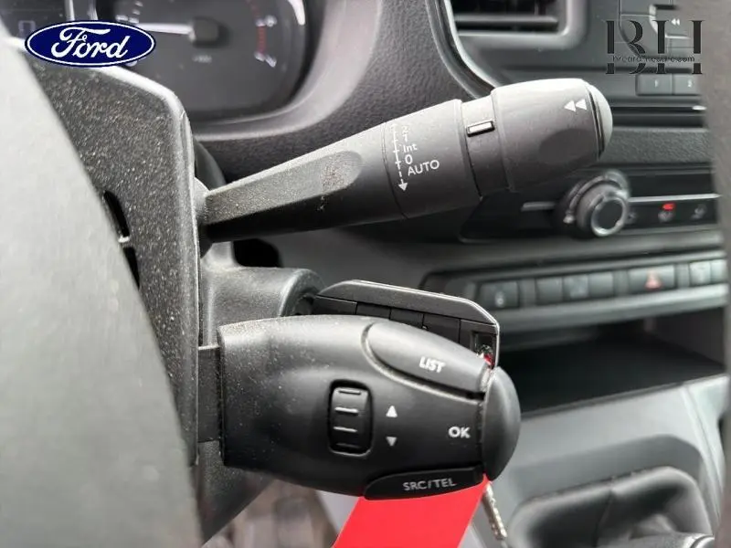 Gros plan sur les commandes au volant côté gauche d’un Citroën Jumpy blanc Banquise, avec commandes audio et essuie-glace.