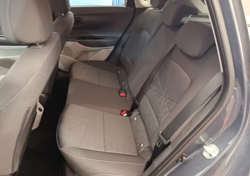 Vue intérieure côté droit des sièges arrière gris foncé du Hyundai Bayon 2023 avec ceinture de sécurité visible.