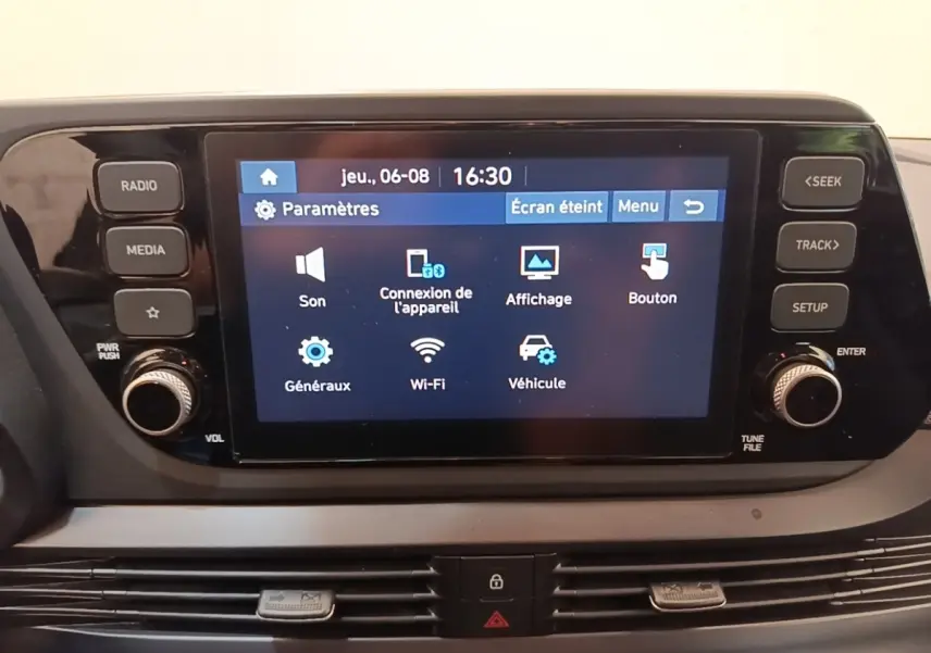 Écran tactile central de la Hyundai Bayon 2023 affichant le menu des paramètres, entouré de boutons de contrôle.