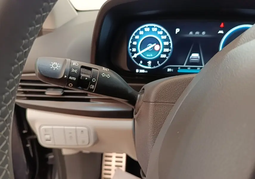 Vue rapprochée du commodo gauche et du combiné d'instruments numérique bleu dans l'habitacle du Hyundai Bayon 2023.