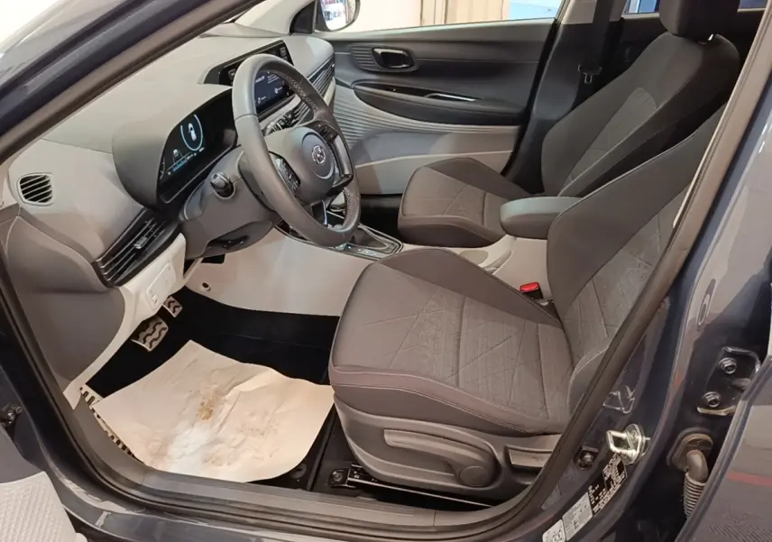 Intérieur avant droit de la Hyundai Bayon gris foncé, avec sièges tissu gris et tableau de bord moderne.