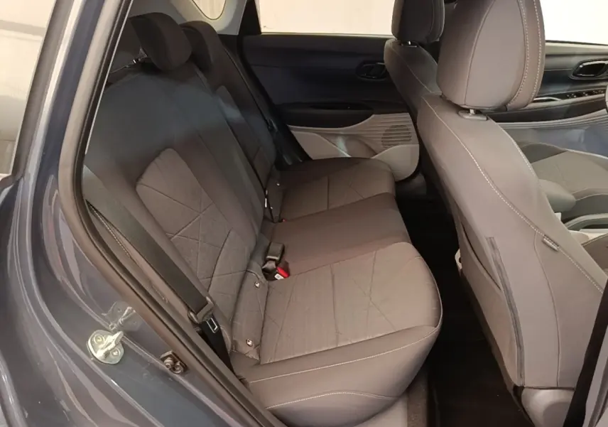 Vue intérieure côté gauche sur les sièges arrière gris foncé du Hyundai Bayon 2023 avec porte ouverte.