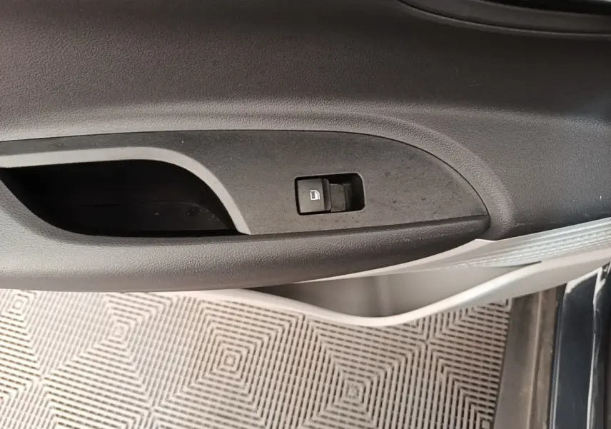 Gros plan sur la poignée intérieure de porte côté conducteur d'une Hyundai Bayon gris foncé avec bouton de verrouillage.