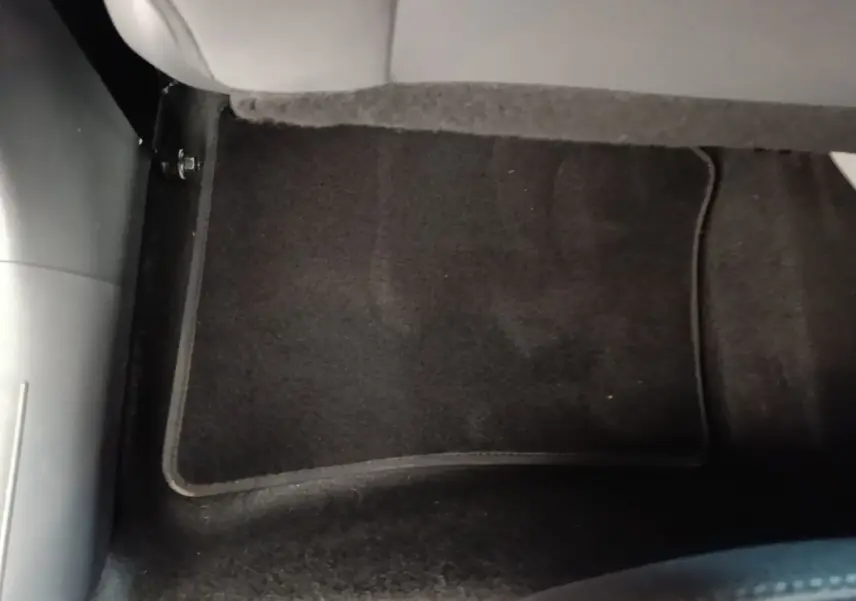 Détail du sol noir avec tapis de sol sous le siège arrière du Hyundai Bayon gris foncé 2023.