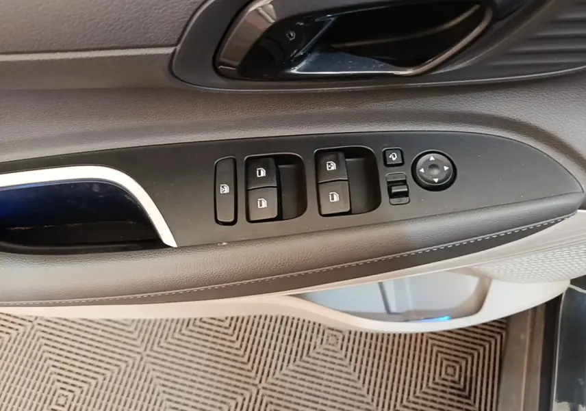 Gros plan sur la commande des vitres et rétroviseurs côté conducteur de la Hyundai Bayon 2023, intérieur gris et noir.