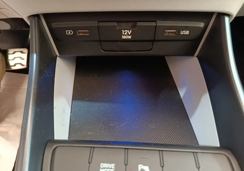 Gros plan sur la console centrale du Hyundai Bayon 2023, avec ports USB, prise 12V et bouton Drive Mode.