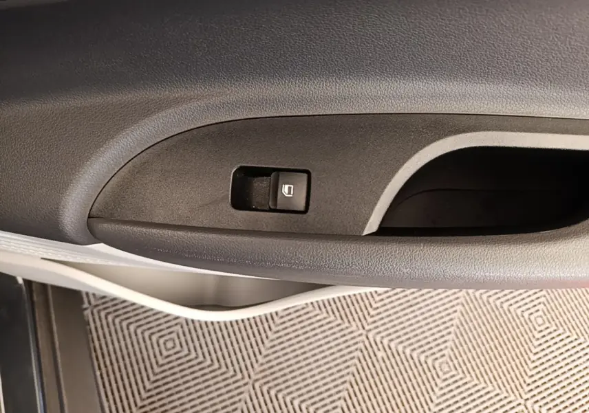 Gros plan sur la commande de verrouillage de porte côté gauche intérieur d'une Hyundai Bayon gris foncé 2023.