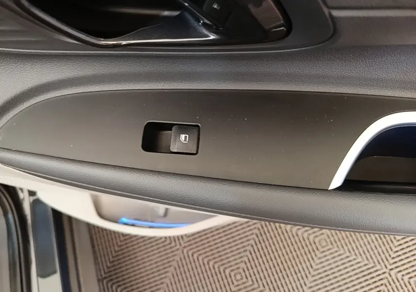 Gros plan sur la commande de verrouillage de porte côté intérieur d’une Hyundai Bayon 2023, finition noire.