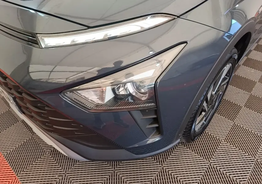 Gros plan sur l'avant droit gris foncé du Hyundai Bayon 2023, mettant en valeur le phare et la calandre.