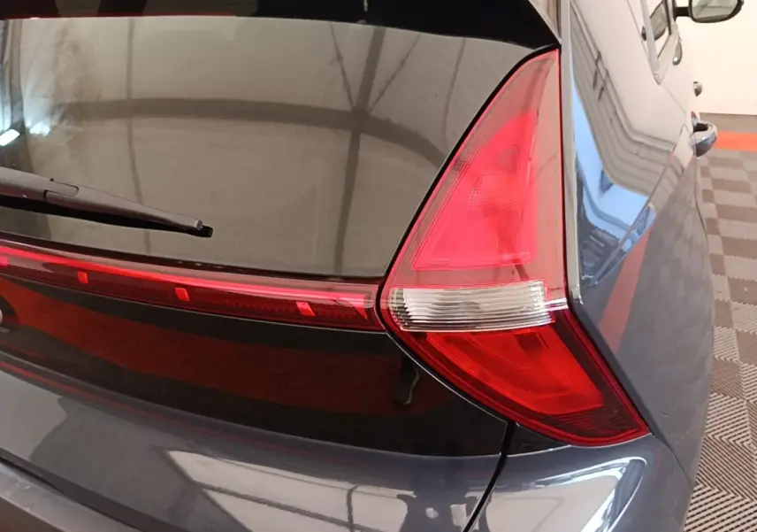 Gros plan sur le feu arrière droit d’une Hyundai Bayon gris foncé 2023, avec lunette arrière et essuie-glace visibles.