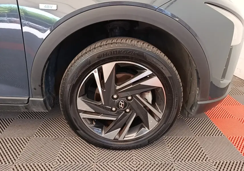 Gros plan sur la roue avant droite gris foncé du Hyundai Bayon 2023 avec jante alliage noire et argentée.