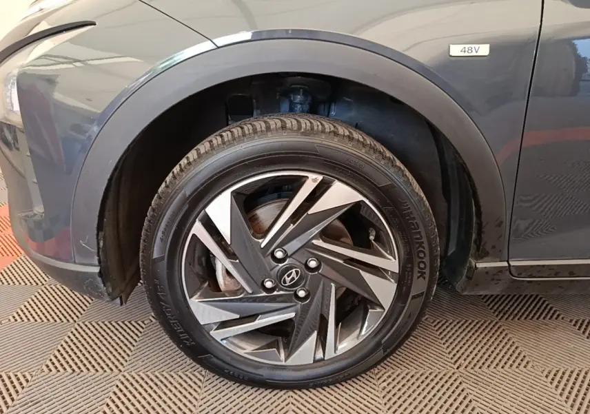 Gros plan sur la roue avant gauche gris foncé d'une Hyundai Bayon 1.0 T-GDI 48V avec jante alliage stylisée.