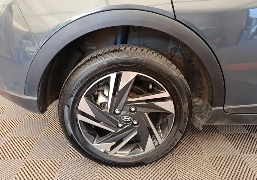 Gros plan sur la roue arrière droite gris foncé d’une Hyundai Bayon 2023 avec jante alliage au design géométrique.