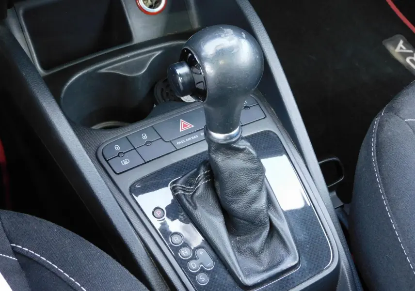 Gros plan sur le levier de vitesse automatique cuir noir de la SEAT IBIZA Cupra 2011 avec console centrale brillante.