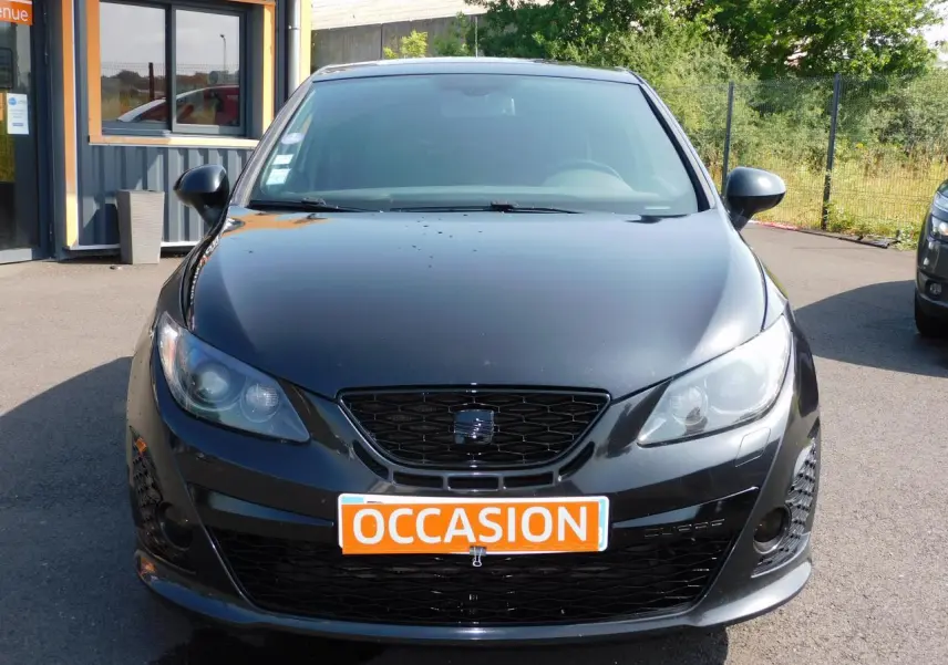 Vue frontale d'une SEAT IBIZA Cupra noire avec calandre noire et plaque orange "OCCASION" visible.