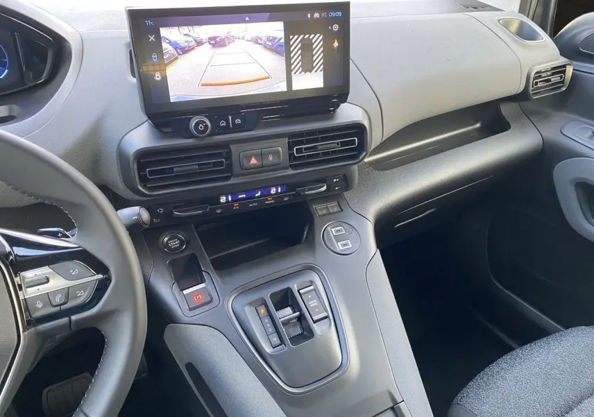 Vue intérieure côté passager du tableau de bord gris noir du Peugeot Rifter 2025 avec écran tactile et caméra de recul affichée.