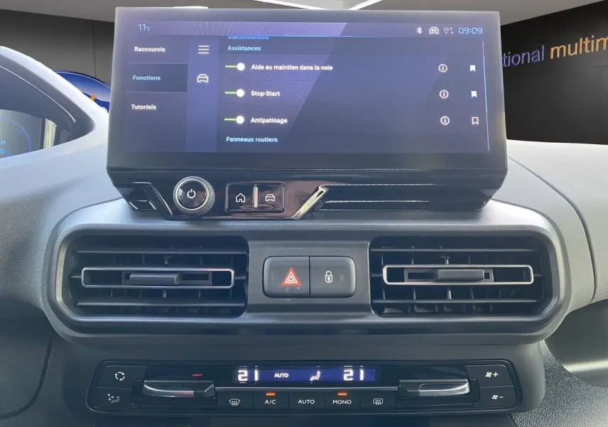 Vue rapprochée du tableau de bord du Peugeot Rifter 2025 avec écran tactile et commandes de climatisation.