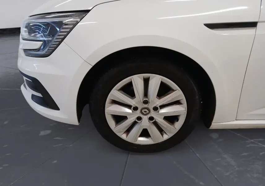 Gros plan sur la roue avant gauche et le phare d’une Renault Mégane IV blanche, version PH2 BlueDCI 115 Zen de 2020.