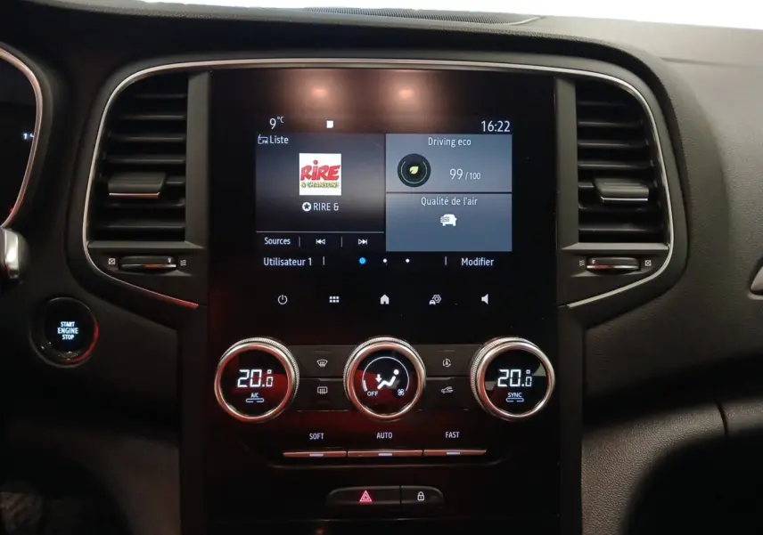 Tableau de bord de Renault Mégane IV blanc, vue frontale sur l'écran tactile et commandes de climatisation.