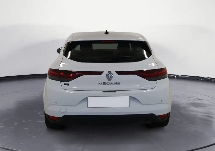 Vue arrière d'une Renault Mégane IV blanche de 2020 avec feux allongés et logo central visible.