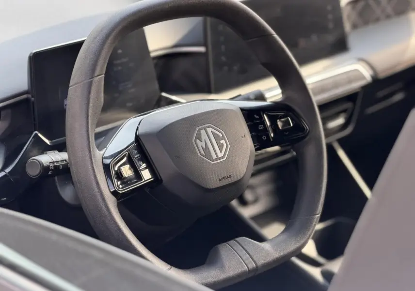 Vue rapprochée du volant noir de la MG3 1.5 Hybrid+ 195 Comfort avec logo MG au centre et commandes intégrées.