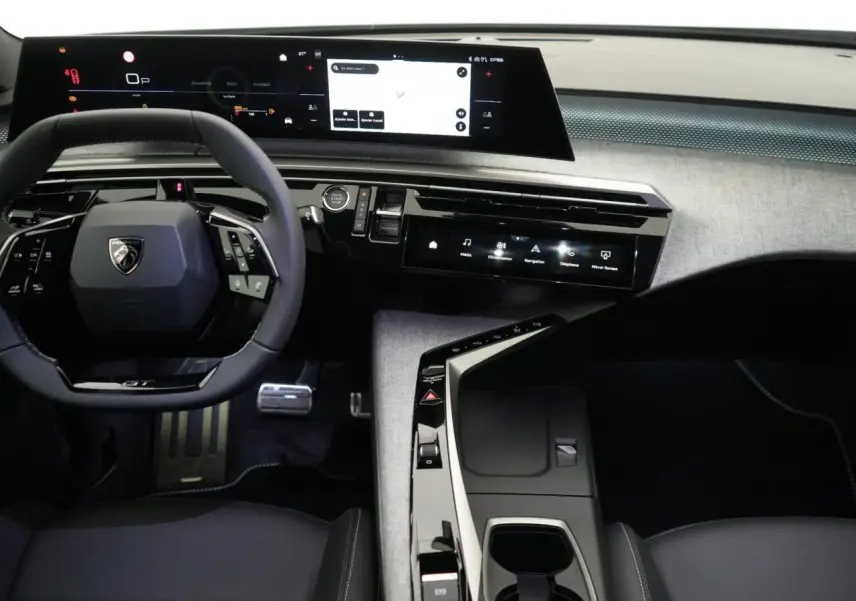Vue intérieure du tableau de bord et volant du Peugeot 3008 Hybrid 2026, avec écran incurvé panoramique et console moderne.