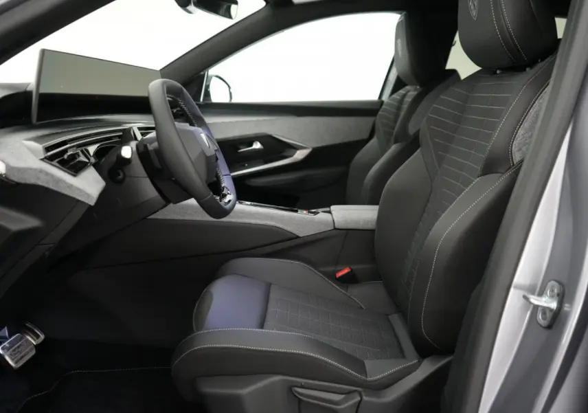 Vue intérieure côté conducteur du Peugeot 3008 gris Artense 2026, sièges noirs avec surpiqûres blanches et tableau de bord moderne.