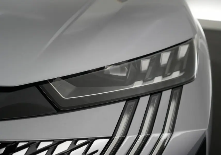 Gros plan sur le phare avant droit du Peugeot 3008 gris Artense, mettant en valeur les feux LED en forme de griffes.