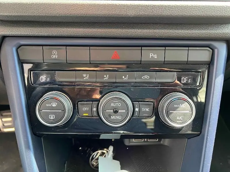 Panneau de commande de climatisation automatique bi-zone du Volkswagen T-Roc gris, avec boutons et réglages visibles.