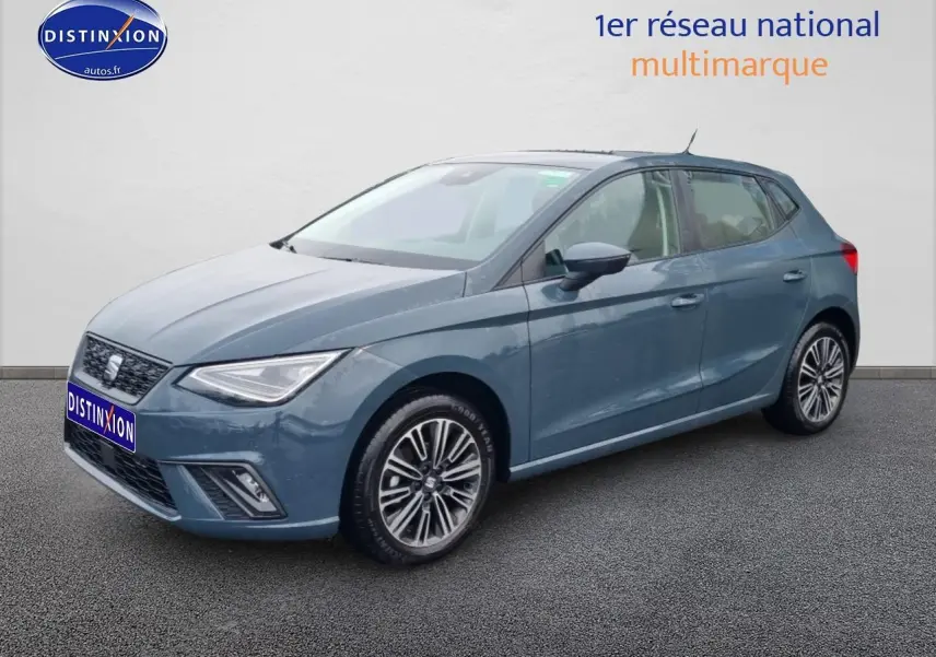Vue 3/4 avant d'une SEAT Ibiza 1.0 TSI 95 Copa bleu gris avec jantes alliage et phares LED triangulaires.