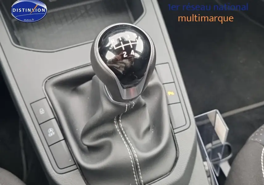 Gros plan sur le levier de vitesses manuel noir de la SEAT Ibiza 2025, avec coutures blanches visibles sur la garniture.