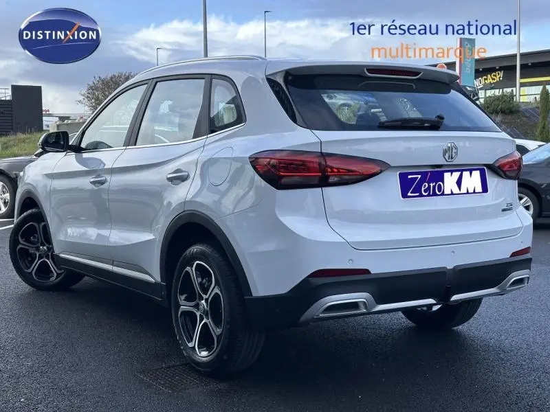 Vue 3/4 arrière droite du SUV blanc MG ZS Hybrid+ 197ch Comfort avec jantes alu et feux arrière LED.