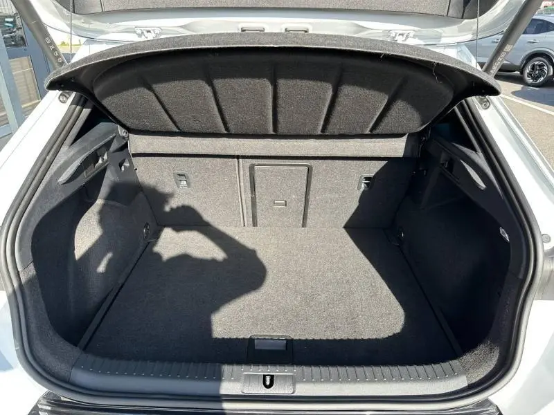 Coffre ouvert vu de l'arrière d'un CUPRA Formentor blanc Nevada métallisé, montrant un espace de chargement propre et spacieux.