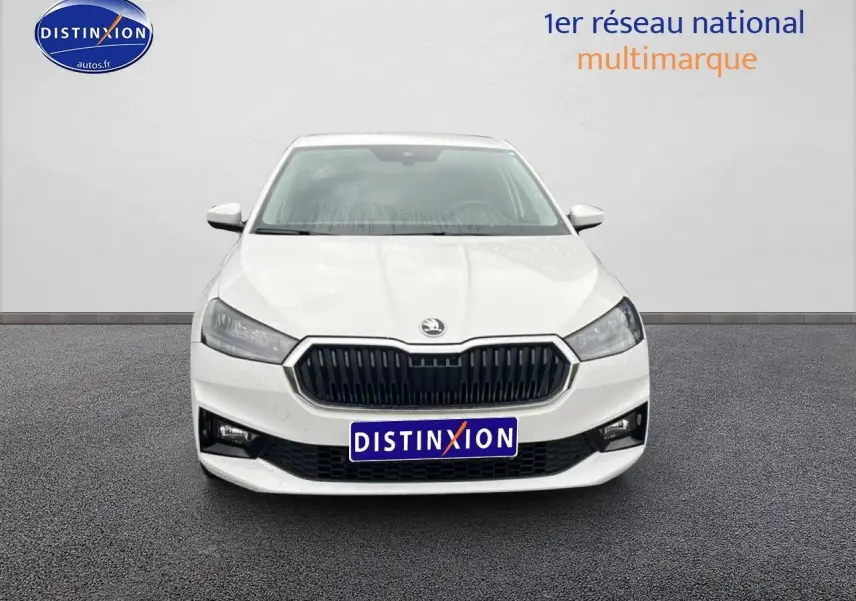 Vue frontale d'une Skoda Fabia blanche 2025 avec calandre noire et phares LED allumés.
