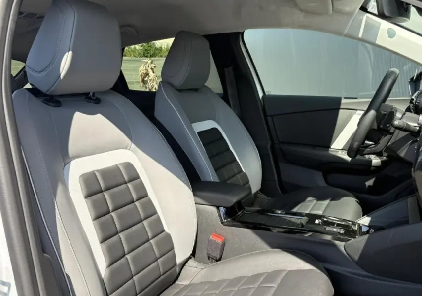 Vue intérieure du tableau de bord et écran tactile central de la Citroën C4 Hybrid 145 CH 2025 en blanc Okenite.